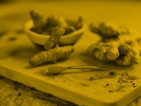 Integratore di curcuma e ciotola di spezia accanto a un paziente intento a controllare la glicemia.